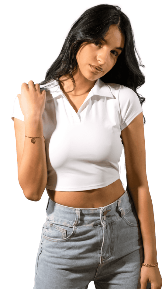Woman wearing a white cropped polo shirt and light blue jeans on a white background