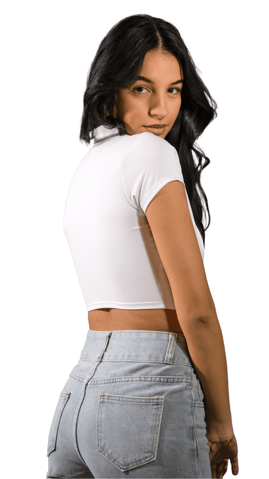 Woman wearing a white crop top and light blue jeans on a white background
