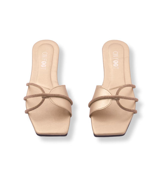 Pair of beige sandals with brown straps on a white background
