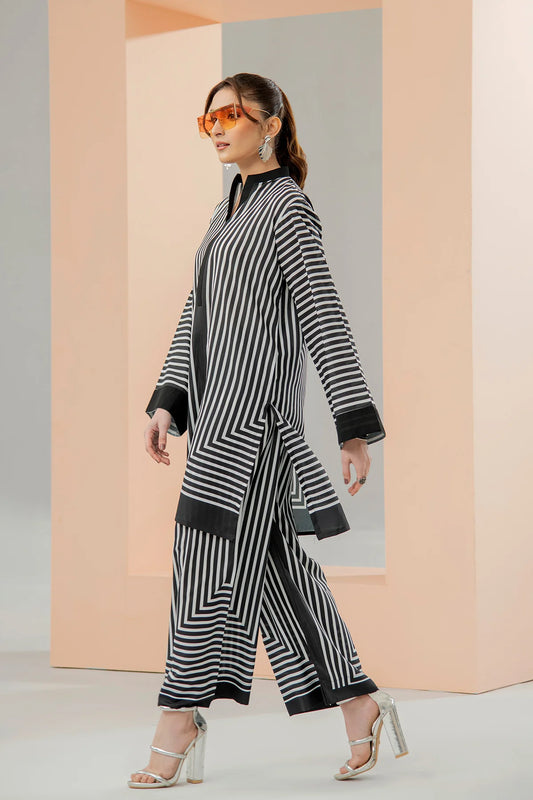 Woman wearing a black and white striped outfit with sunglasses against a geometric background