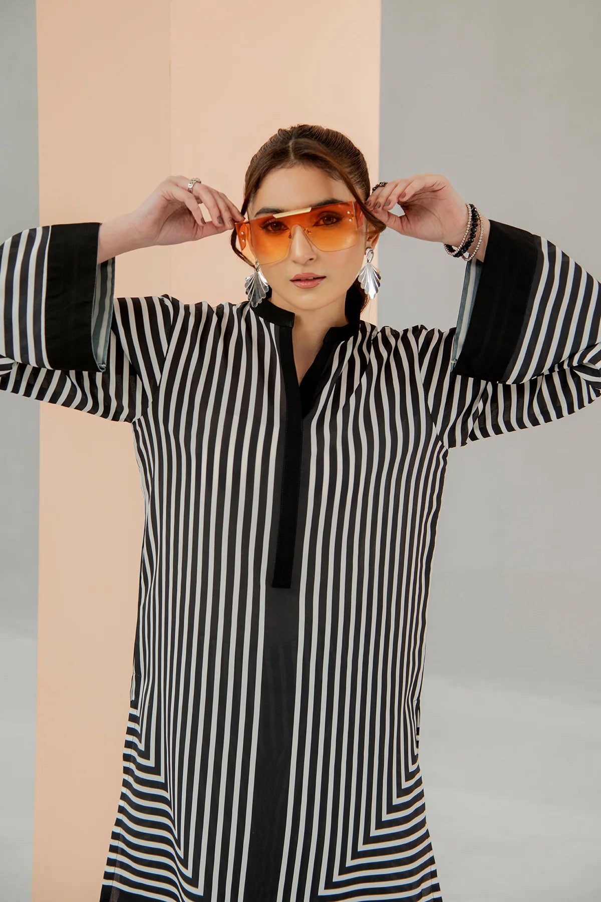 Lady wearing a black and white striped shirt with a plain background