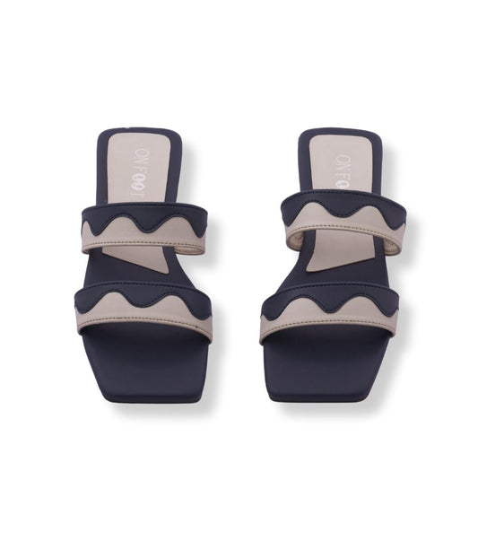 Pair of navy and beige sandals on a white background