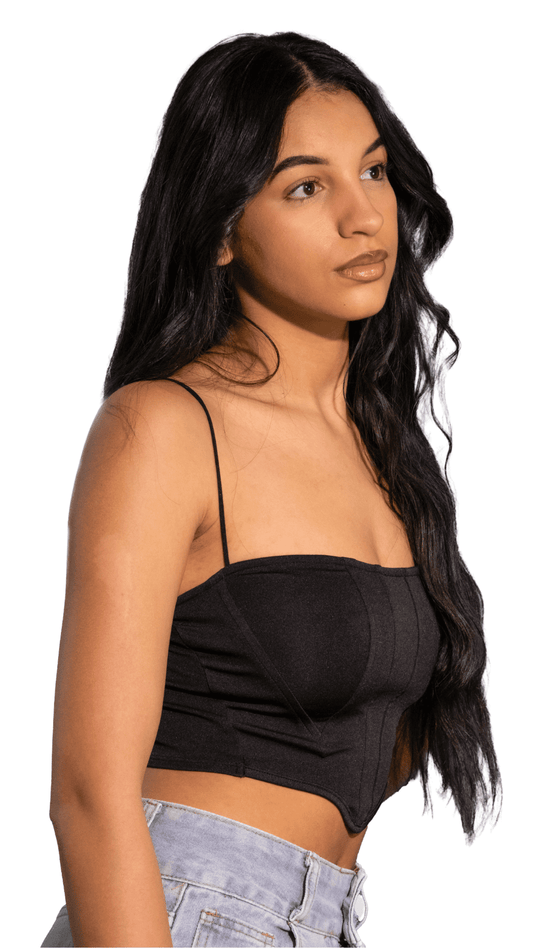 Woman wearing a black strap top and light blue jeans on a white background