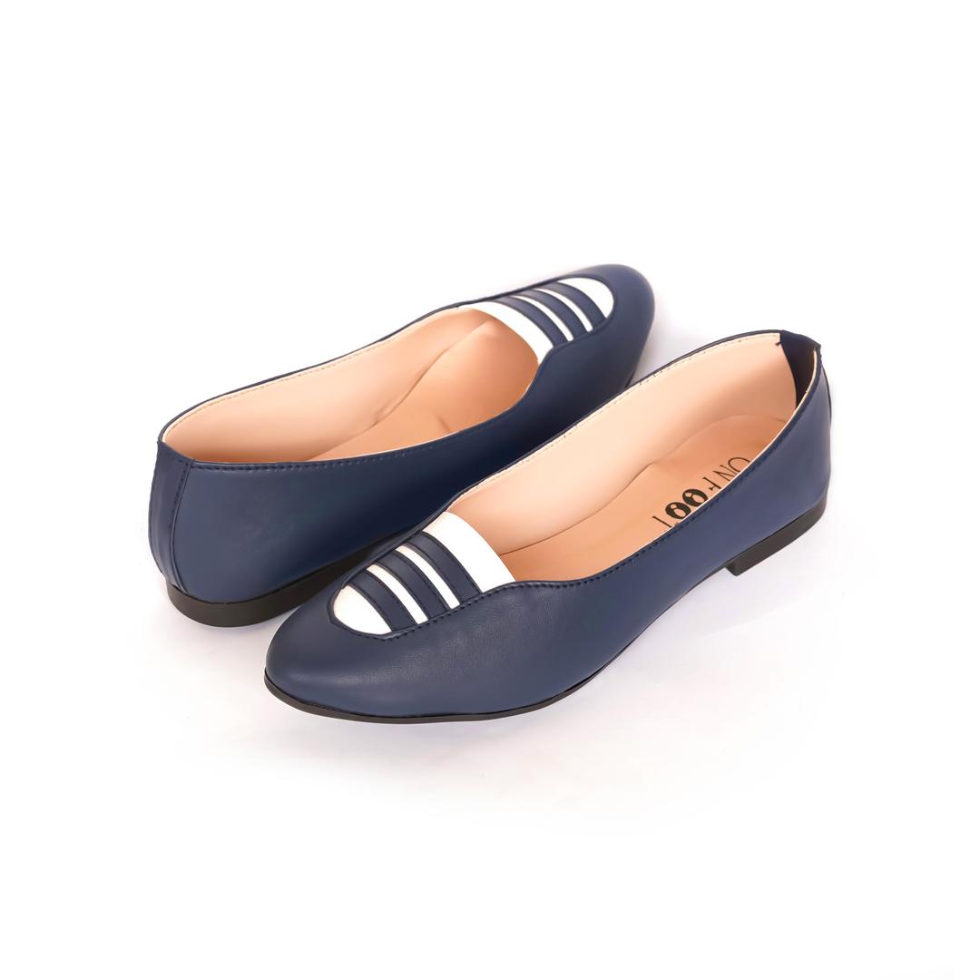 Pair of navy blue flat shoes with white stripes on a white background