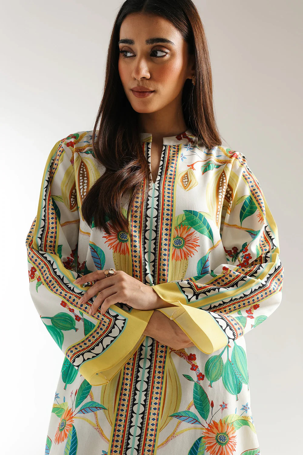 Woman wearing a colorful patterned dress against a plain background