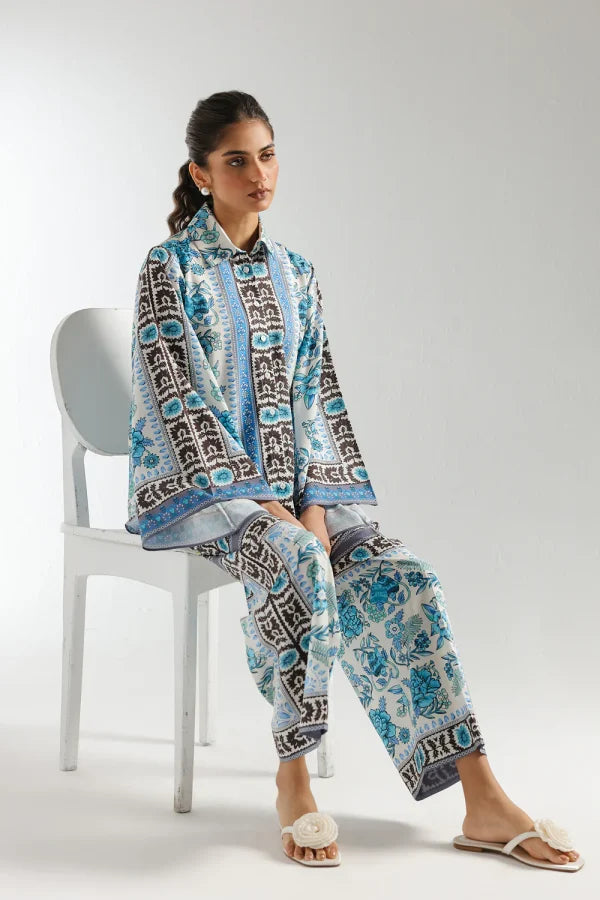 Woman sitting on a chair wearing a patterned outfit with a white background