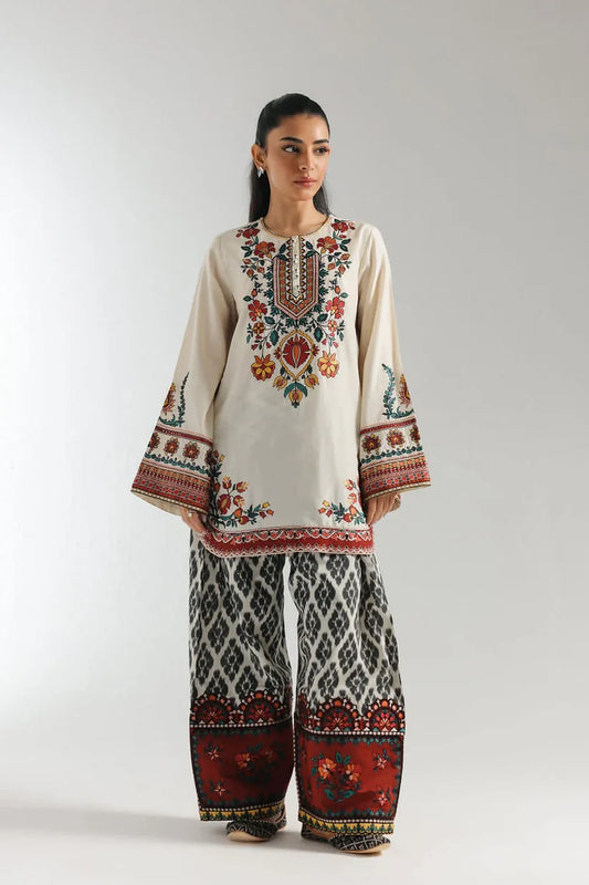 Woman wearing a traditional embroidered outfit with a white background