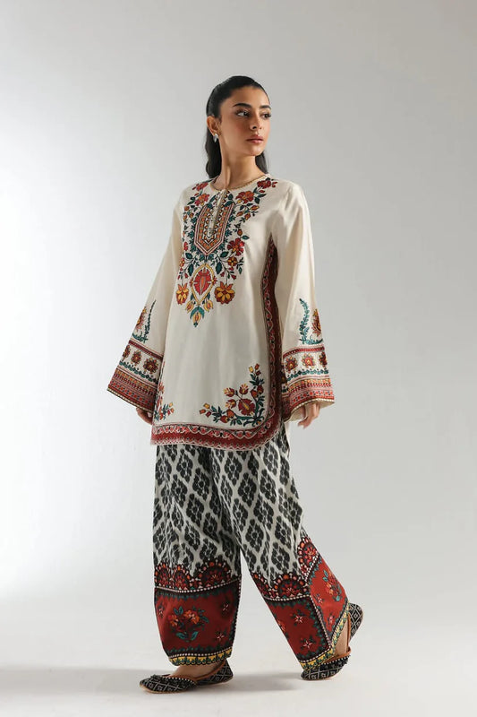 Woman wearing a traditional embroidered outfit with a white background