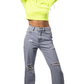 Lady wearing a bright yellow cropped hoodie and ripped gray jeans on a white background