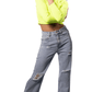 Lady wearing a bright yellow cropped top and high-waisted blue jeans on a white background