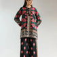 Woman wearing a traditional outfit with floral patterns on a plain background