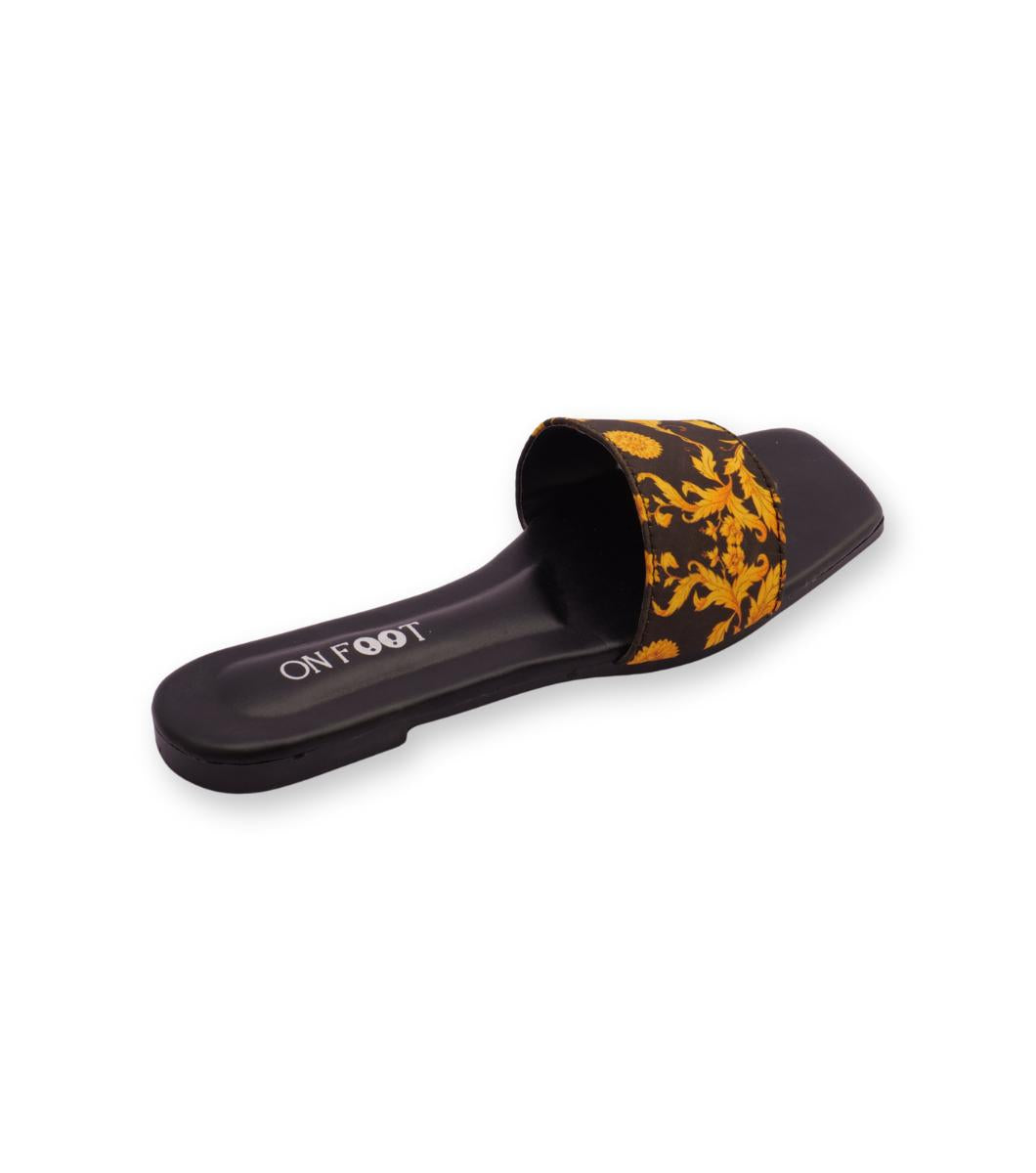 Black slide sandal with yellow pattern on a white background