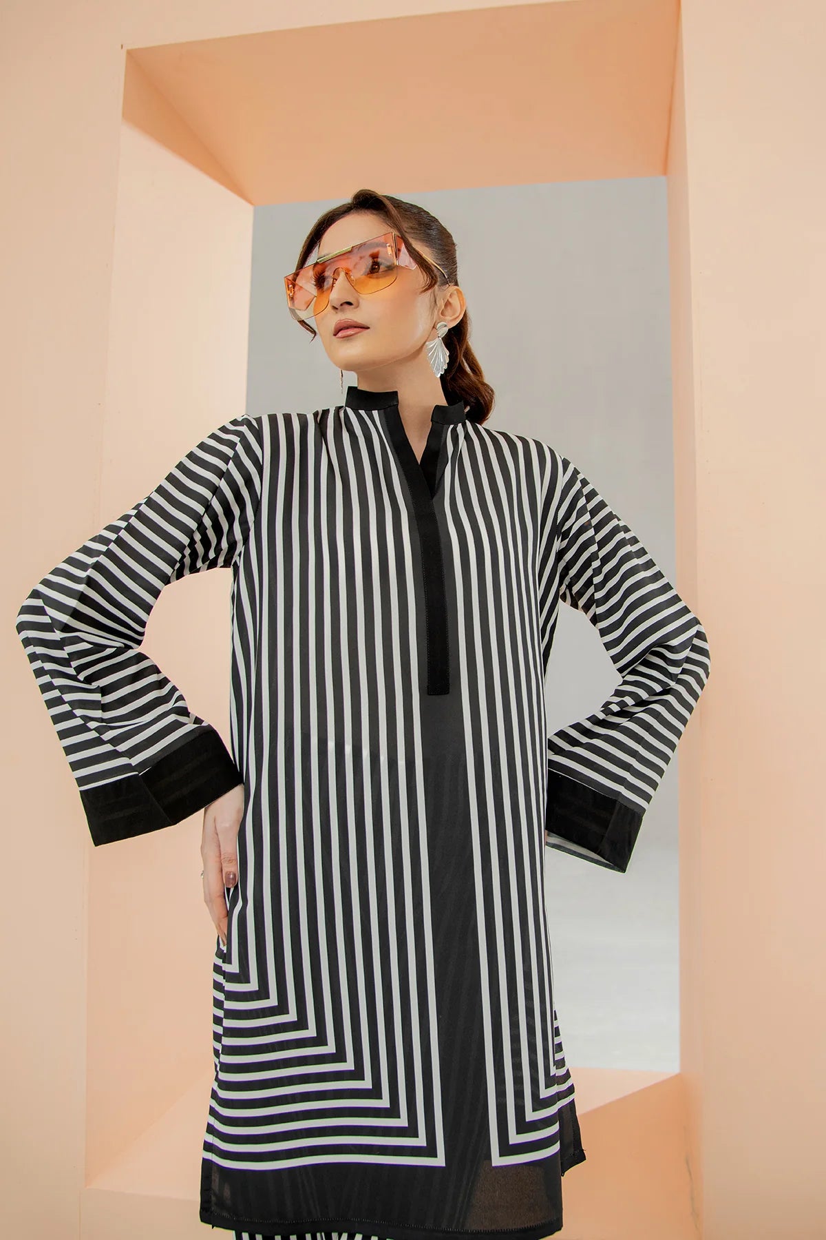 Woman wearing a black and white striped dress with a plain background
