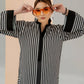 Lady wearing a black and white striped shirt with a plain background