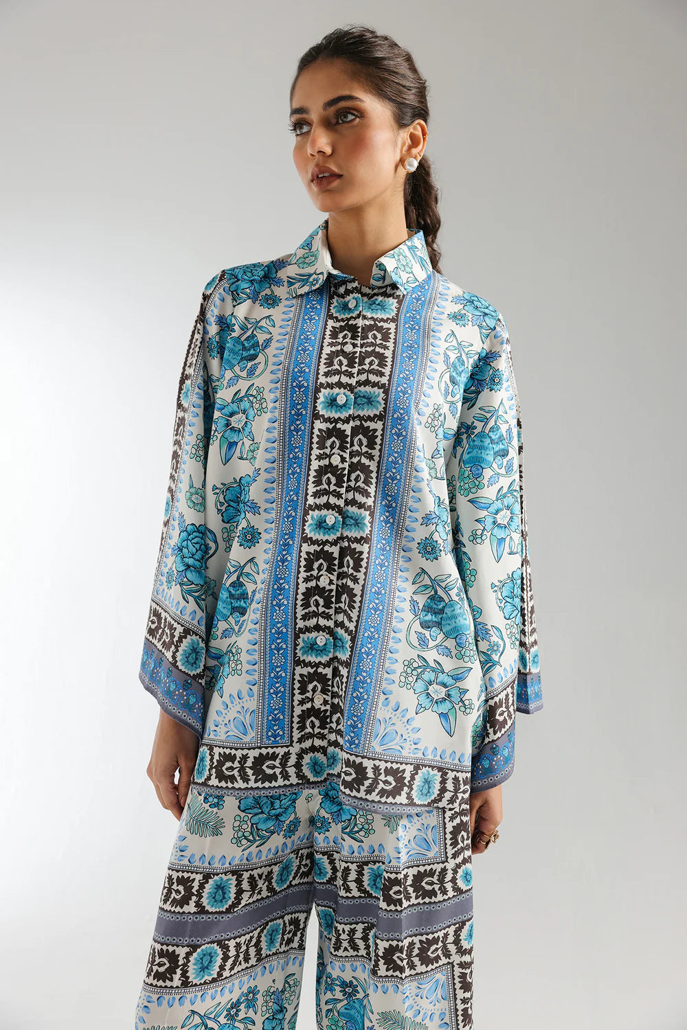 Woman wearing a patterned outfit against a plain background