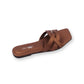 Brown sandal with criss-cross straps on a white background