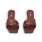 Pair of brown sandals with woven design on a white background