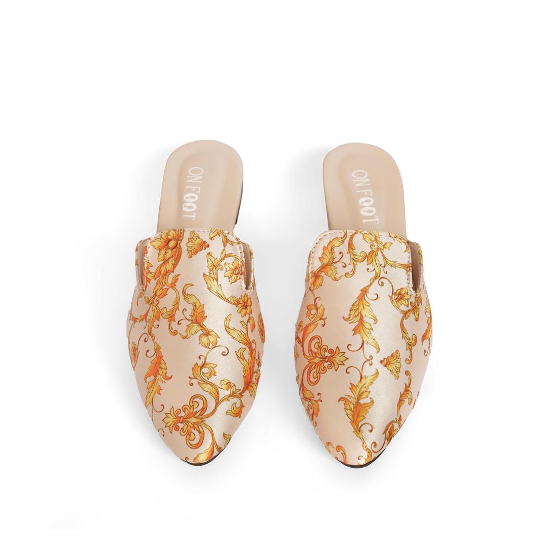 Pair of floral-patterned mules on a white background