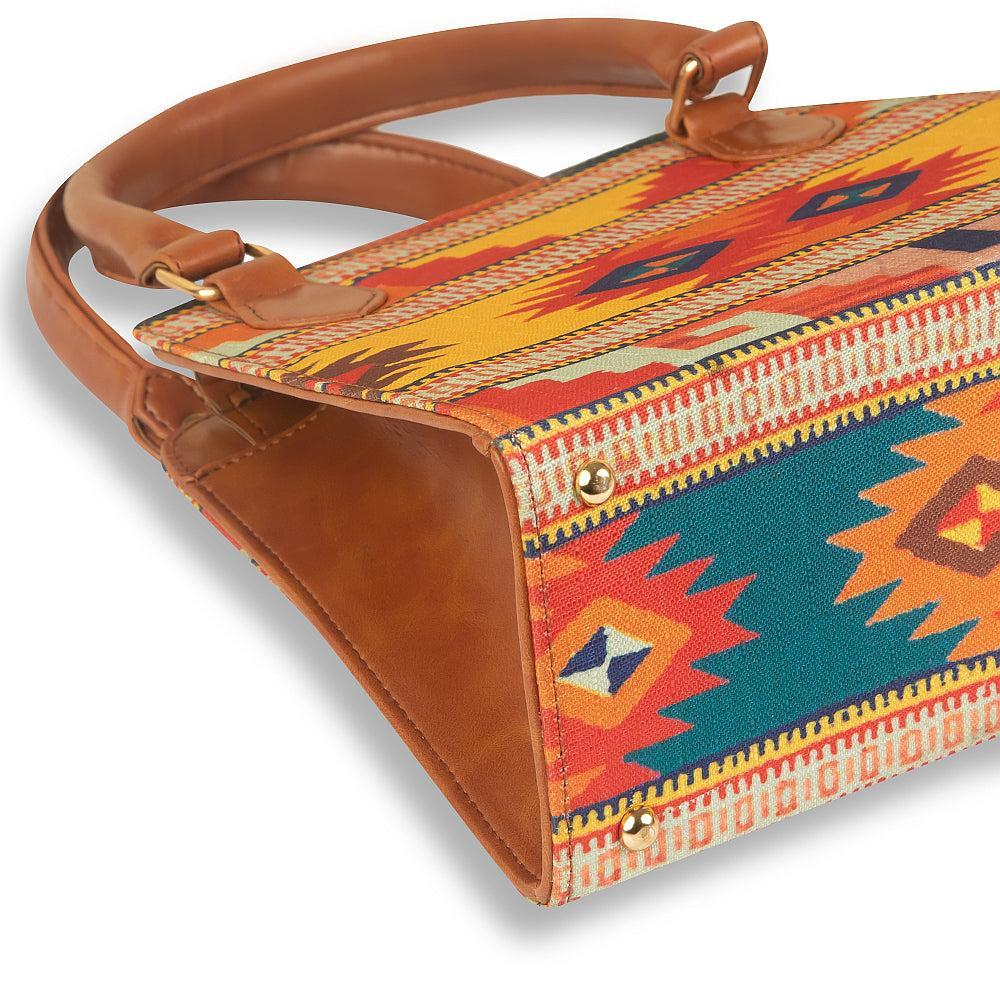 Colorful patterned handbag with brown leather accents on a white background