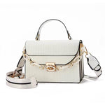 White handbag with gold chain strap on a white background