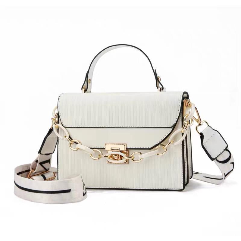 White handbag with gold chain strap on a white background