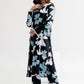 Woman wearing a black floral dress on a white background