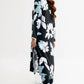 Woman wearing a black floral dress with blue flowers on a white background