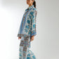 Woman wearing a blue and white patterned outfit on a white background