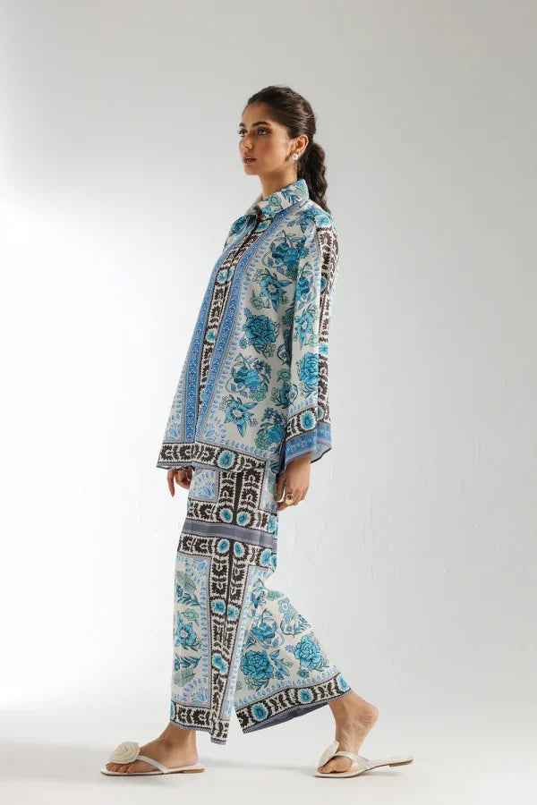 Woman wearing a blue and white patterned outfit on a white background