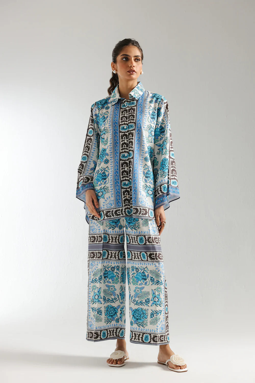 Woman wearing a patterned outfit on a plain background