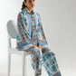Woman sitting on a chair wearing a patterned outfit with a white background