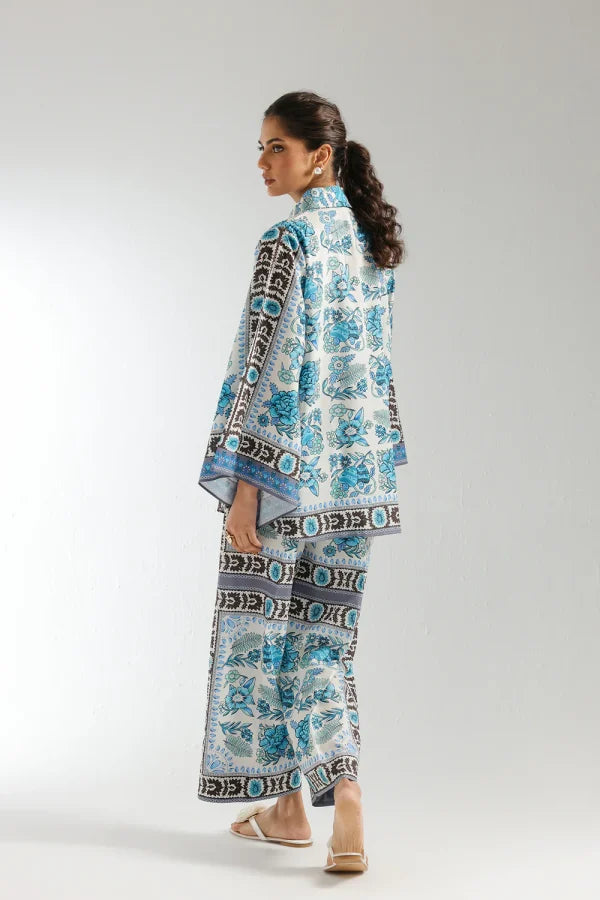 Woman wearing a blue and white patterned outfit on a plain background