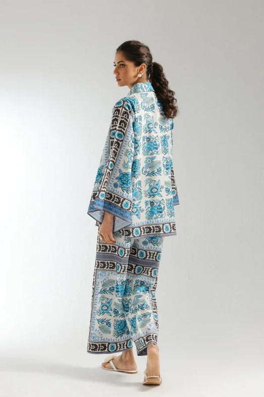 Woman wearing a blue and white patterned outfit on a plain background