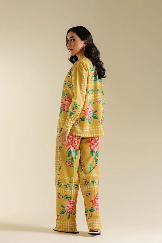 Woman wearing a yellow floral outfit on a beige background