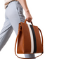 Brown leather bag with black and white stripes held by a person wearing light gray pants on a white background