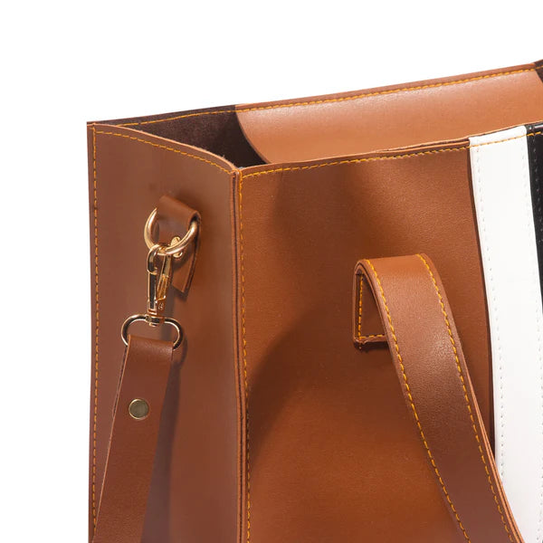 Close-up of a brown leather handbag with gold hardware on a white background